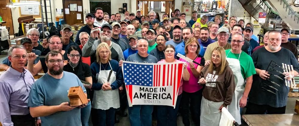 Cutco factory workers on the shop floor holding a Made in America banner