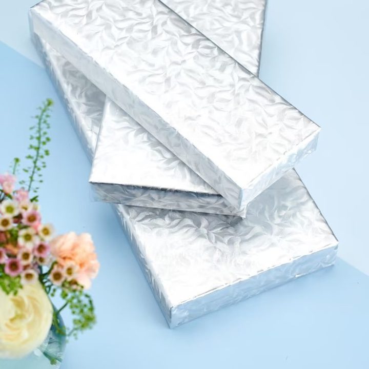 Silver-wrapped gift boxes styled with fresh flowers